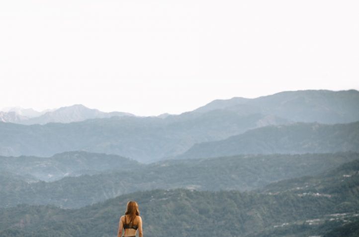 woman standing on cliff during daytime