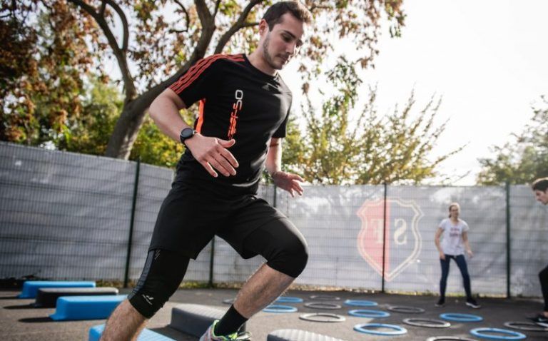 man in black crew neck t-shirt and black shorts running on blue and white trampoline