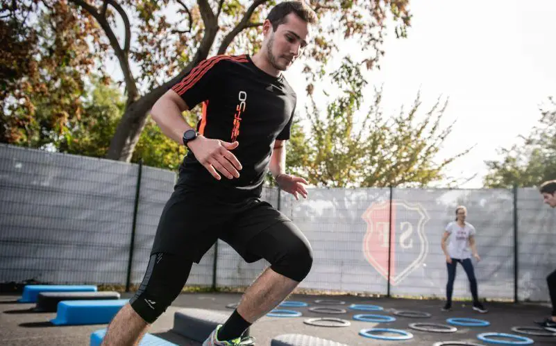 man in black crew neck t-shirt and black shorts running on blue and white trampoline